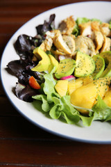 Salad with Chicken avocado and mango on wood background