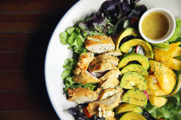 Salad with Chicken avocado and mango on wood background