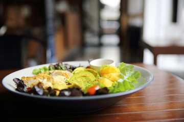 Salad with Chicken avocado and mango on wood background