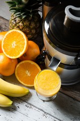 Fresh juice and juicer. Photo on wooden background