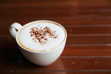 cappuccino coffee on wood background in coffee shop