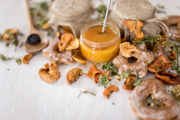 New trend honey, tea leaves, dried apples on a white wooden background