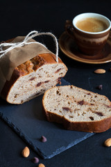 Banana bread with nuts and chocolate drops, with cup of coffee in rustic style. Selective focus, dark food photo. 