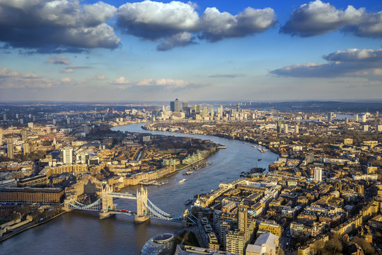 London, England - Aerial skyline of famous Tower Bridge with Red Double Decker bus and Canary Wharf skyscrapers at the background