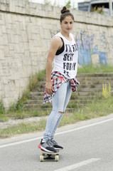 Beautiful young woman driving skateboard and moving fast