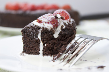 Slice of chocolate fudge cake covered in cream