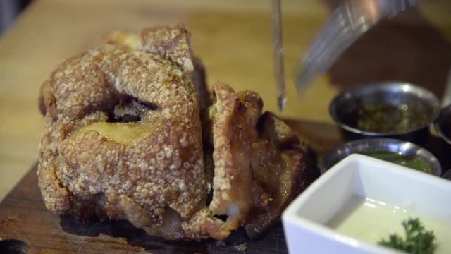 Fried German pork knuckle (eisbein) sliced with knife closeup time-lapse full HD.