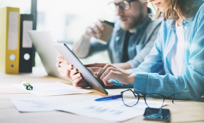 Coworkers work creative studio.Production managers team working new project.Young business crew discussion startup.Laptop computer on wood table,using digital tablet.Blurred,film effect.Horizontal.