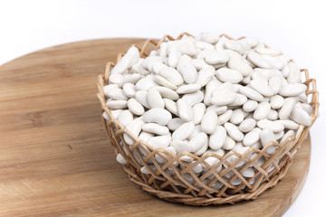 Pile of white beans in the woven wooden basket