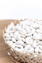 Pile of white beans in the woven wooden basket