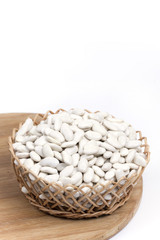 Pile of white beans in the woven wooden basket