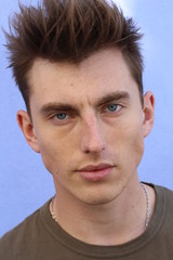 Fototapeta premium Man beauty concept. Portrait of young and handsome man posing over blue background