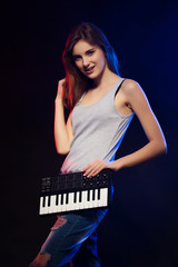 Fototapeta na wymiar young woman holding an electronic mini piano