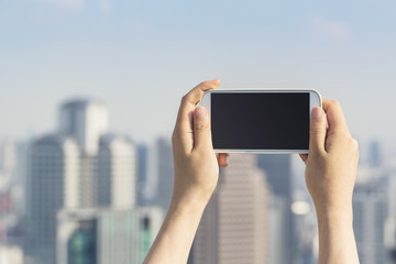 Person holding a smartphone on an urban background