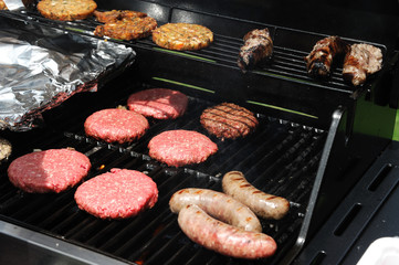 close up on barbecue grill for ground beef patty and sausage
