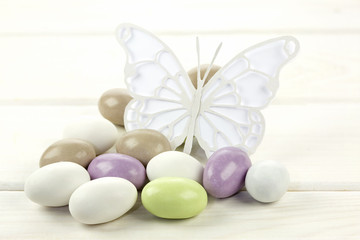 Colored sugared almonds and papery butterfly