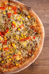Vegetarian pizza on rustic wooden background, fast food
