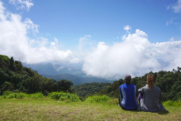 Fototapeta na wymiar Traveler sitting in front of beatiful mountain landscape