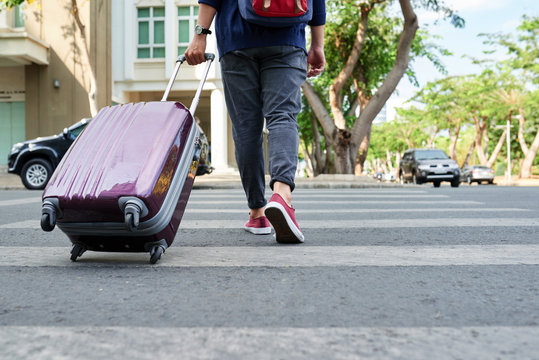 Cropped Image Of Traveler With Big Suitcase Crossing Road