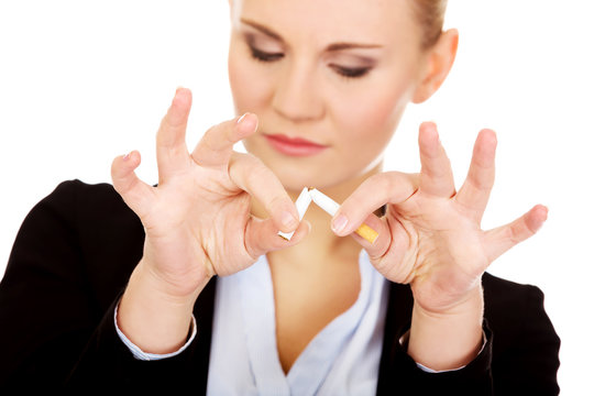 Young business woman breaking cigarette