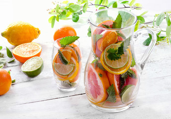 Pitcher and glass with citrus fruits