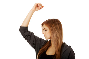 Fototapeta na wymiar Pretty teen woman sniffing her armpit