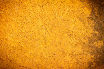 Abstract background texture cement wall in  orange yellow tone. Grunge wall texture in orange yellow tone. Cement texture and background. Center focus. Blurry edges. Dark edged.