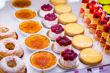 Pastry shop with variety of donuts, Creme brulee, cakes with fruits and berries