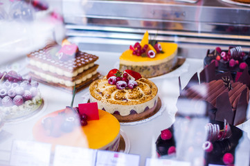 Pastry shop with variety of cakes with fruits and berries