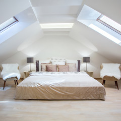 Bright attic bedroom in the fashionable apartment