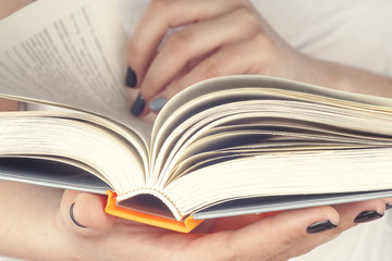 Young girl reading an  open book  old book. Books and reading are essential for self improvement, gaining knowledge and success in our careers, business and personal lives.