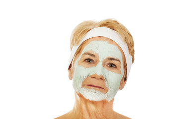 Relaxed elderly woman in facial mask