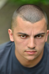 Obraz premium Portrait of serious and sad handsome young man outdoors in natur