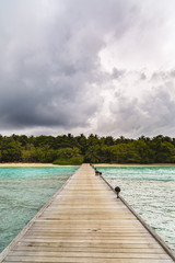 jetty to a little tropical island in the turquoise indian ocean, maldives, way to a travel destination