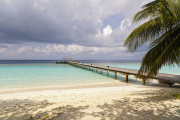 Fototapeta na wymiar jetty to a little tropical island in the turquoise indian ocean, maldives, way to a travel destination