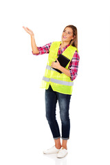Female builder in a helmet and a vest with a notebook