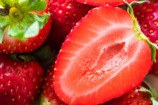 Pile of fresh strawberries on a wooden table. Macro shot.