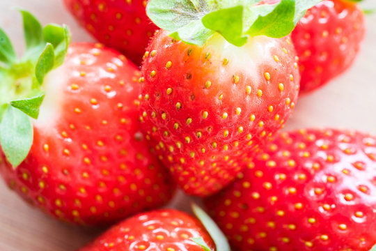 A fresh strawberries on a wooden table. Detail shot.