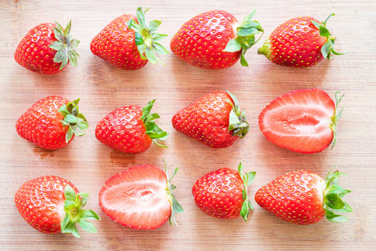 Strawberries on a wooden table. Arranged in a order.