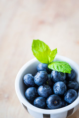Blueberries in a small cap on a wooden table. macro shot.