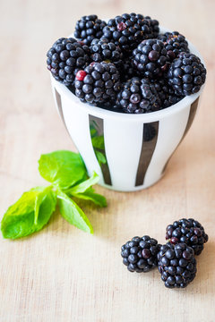 Blackberries in a small cap. Selective focus. Vertical view.