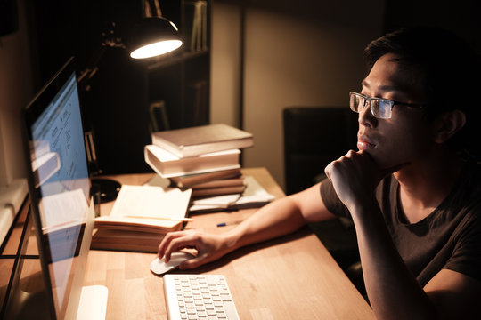 Pensive man working with computer and thinking in the evening