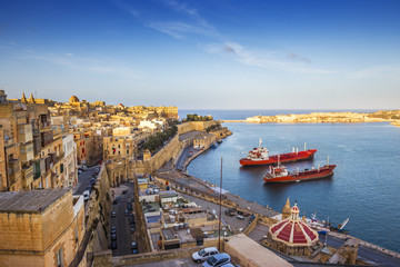 Valletta, Malta - The Grand Harbor and the ancient walls of Valletta with ships at sunset