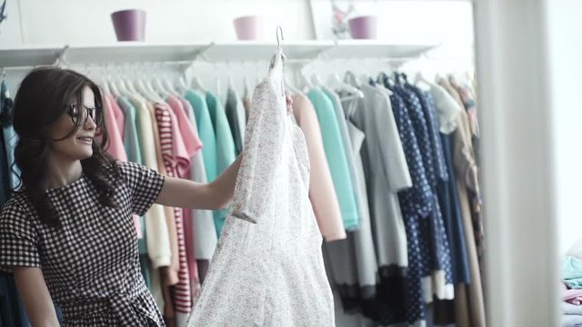 Beautiful girl trying dress near mirror in room