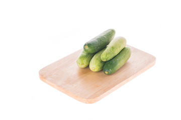 Ripe cucumber on chopping board white background