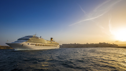 Fototapeta na wymiar Valletta, Malta - Cruise ship at the Grand Harbour of Valletta at sunset