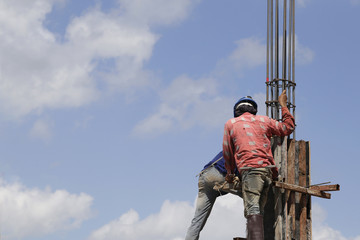 worker mounter assembling concrete formwork at construction site