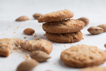 Cookies pile with chocolate chip and almond on light textile background. Delicious morning snacks for breakfast, brunch and lunch. Appetizing, healthy and fast food