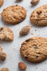 Cookies pile with chocolate chip and almond on light textile background. Delicious morning snacks for breakfast, brunch and lunch. Appetizing, healthy and fast food