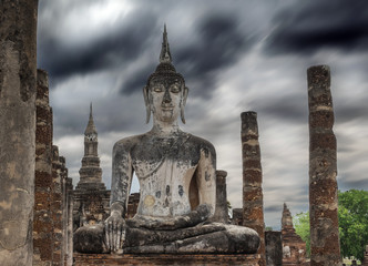Buddha statue in old temple with cloudy storm